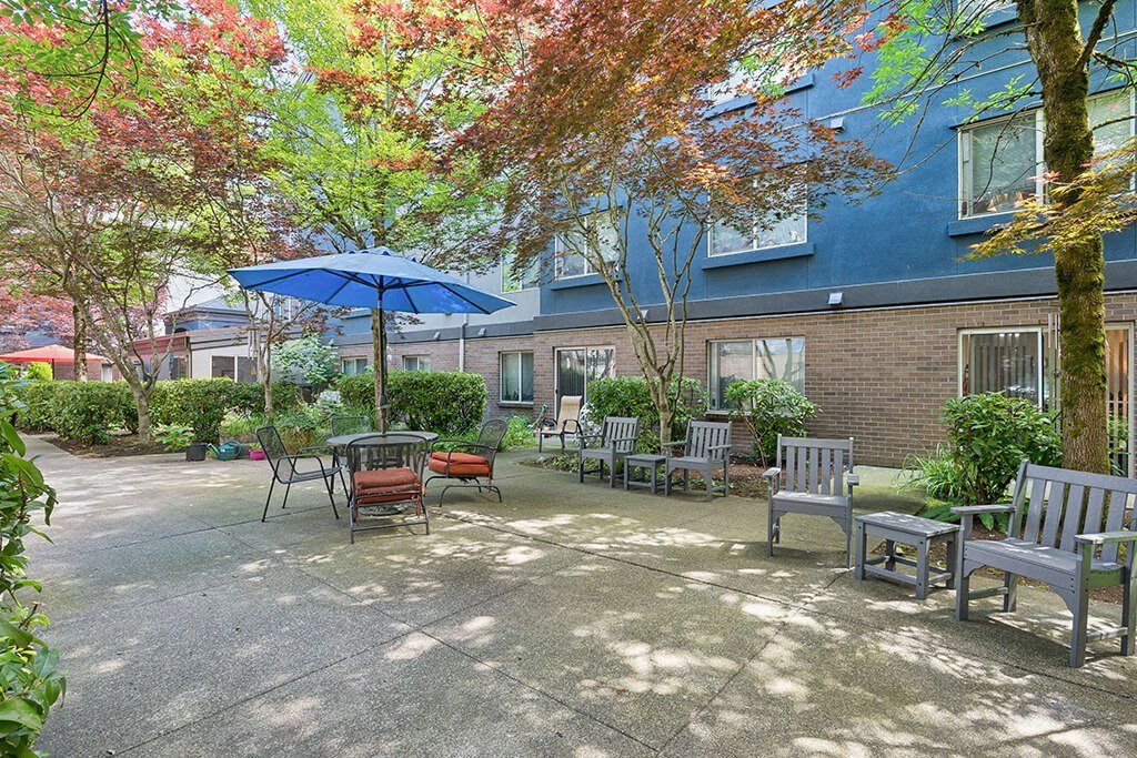 Courtyard with tables and chairs and an umbrella at Boardwalk in Olympia WA